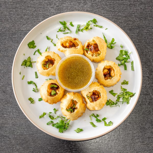 Dasara Indian Cuisine's pani puri, with six crispy shells filled with potato and chickpeas, and a cup of spiced water.